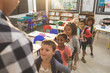 © WavebreakMediaMicro - School kids standing and forming a queue in classroom at school