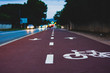 Perspective view of bike lane near street with blurred cars and lights