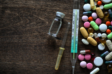 Wall Mural - Medications on a textured wooden background