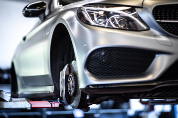 Car in a garage for maintenance, oil/tyre change (shallow DOF; color toned image)