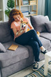 © silverkblack - Happy teenage girl is hugging beautiful shiba inu dog sitting on sofa in modern apartment smiling. Domestic animals, happiness and youth lifestyle concept.