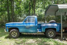 Old Vintage Blue Pickup Truck Parked In A Backyard