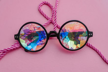 Designer Glasses With Kaleidoscope Lenses With A Rope On A Pink Background