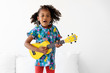 © Lisa Tichané - Portrait of young girl dancing on bed while playing the guitar