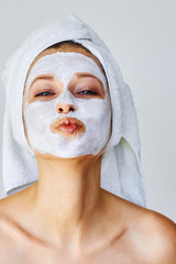 Wall Mural - beautiful woman with facial mask on her face. skin care and treatment, spa, natural beauty and cosme