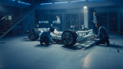 Leinwandbilder - Automobile Engineer Working on Electric Car Chassis Platform, Using Tablet Computer Augmented Reality with 3D CAD Software Modelling. Innovative Facility: Vehicle Frame with Wheels, Engine, Battery