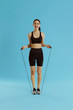 Sport woman with fit body in sportswear and skipping rope