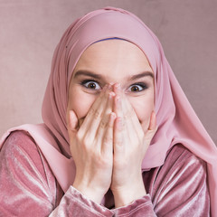 Wall Mural - Close-up of a excited beautiful woman with her hands on mouth