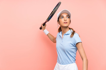 Wall Mural - Young tennis player woman over isolated pink wall