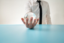 Front View Of A Man In Elegant Shirt And Tie Holding Crystal Sphere In His Hand