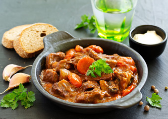 Wall Mural - Beef stew in Burgundy. With carrots, onions, peas and champignons in wine. View from above.