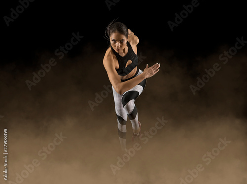 Cuadros en Lienzo Sporty woman running. Smoke background