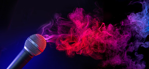 microphone in a purple-bluish smoke on black background