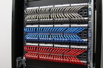 Ethernet switches connected by patch cords to patch panels in the colors of the flag of Russia. Installed in a telecommunications rack.