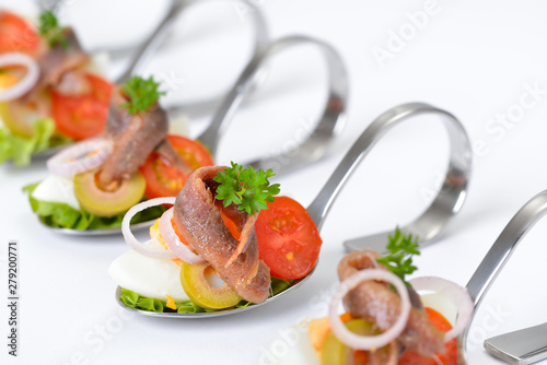 Fotografía Feine Fischhäppchen mit Ei und Sardelle auf Häppchenlöffel vor weißem Hintergrun