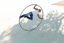 Cyr Wheel Acrobat Training Tricks In A Park In Sunny Day