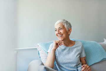 happy woman relaxing on her couch at home in the sitting room. portrait of beautiful mature woman sm