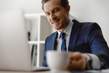 Poster - Handsome man putting cup on the table and smiling