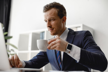 Poster - Businessman is drinking coffee while checking email
