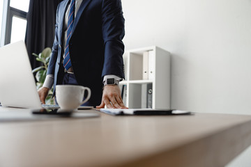 Wall Mural - Businessman standing in the office with his hands on the table