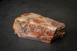 Red gemstone with colorful structure in many tones formed under high pressure