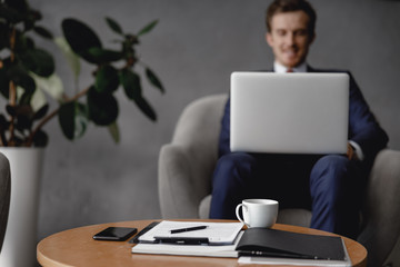 Wall Mural - Selective focus of coffee table with documents and coffee