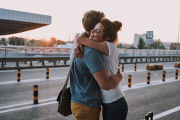 Happy young couple hugging on the street