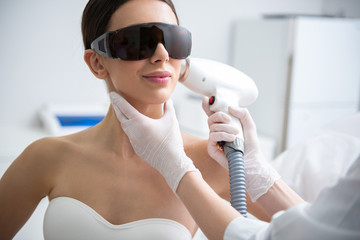 Wall Mural - Smiling lady on face laser epilation procedure