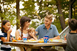 © Cavan for Adobe - Family with kids (6-7,8-9, 12-17 months) eating lunch at picnic table