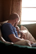 © Cavan for Adobe - Father sitting with baby son (12-17 months) on sofa