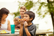 © Cavan for Adobe - Family with kids (6-7, 12-17 months) eating at picnic table