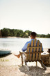 © Cavan for Adobe - Man sitting in chair looking at river