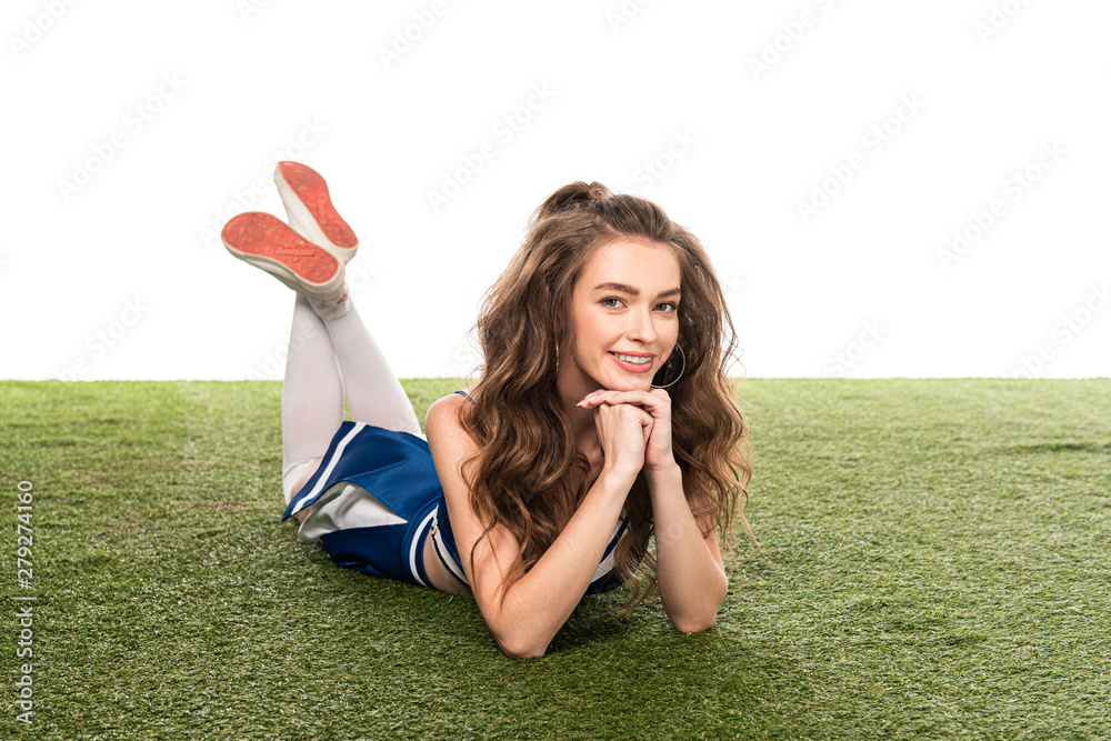 happy cheerleader girl in blue uniform lying on green field isolated on ...