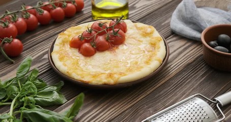 Wall Mural - Cinemagraph - Pizza on the wooden table with ingredients. Motion Photo.