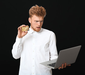 Sticker - Stressed businessman with credit card and laptop on dark background