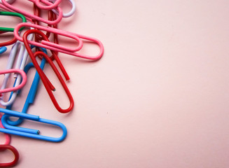 multicolored paper clips on a pink background. The concept is time to school.