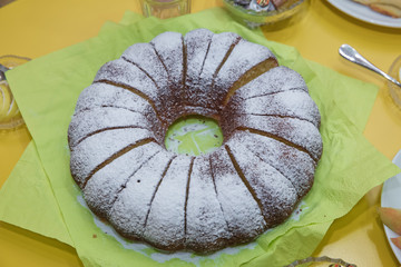 Wall Mural - homemade bundt cake with icing sugar. Hamemade bundt cake with white flour on the green background.