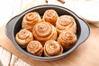 © Pixel-Shot - Baking tray with tasty cinnamon buns on table