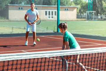 Wall Mural - Father wearing white t-shirt and shorts playing tennis with his girl