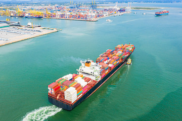 top aerial view of the large TEU containers ship arrival to the port, carriage the shipment from loading port to destination discharging port, transport and logistics services to worldwide