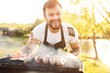 Cheerful guy gesturing thumb up over barbecue