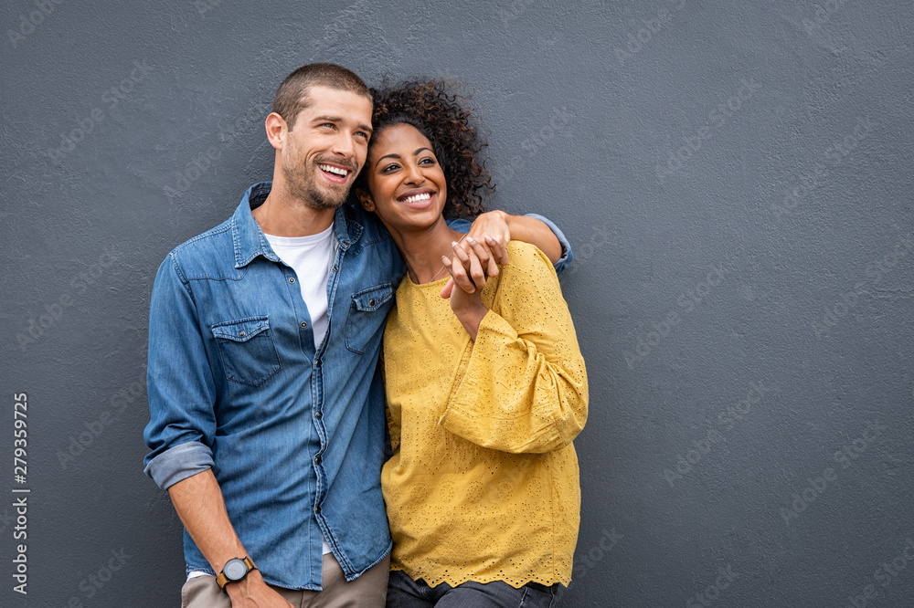 Multiethnic couple in love standing and holding hands - obrazy, fototapety, plakaty 