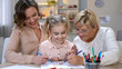 © motortion - Elderly mother, daughter and grandchild drawing by color pencils, time together