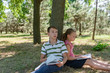 © andov - A boy and a girl do their homework in the park and get ready for school together.