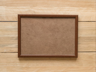 Empty brown wooden photo frame on light brown wooden wall. Mock up