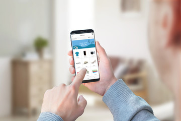 Poster - Guy shopping from home with smart phone. Concept of online store app, or web site. Living room in background.