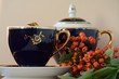 © Olena - Still life of blue service with tea and rowan branches on a light background