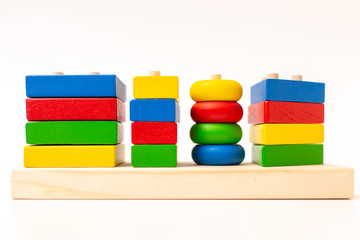 Toy wooden blocks, multicolor building construction bricks over white background. Early education concept