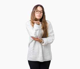 Sticker - Young beautiful brunette hipster woman wearing glasses and winter hat over isolated background looking at the camera blowing a kiss with hand on air being lovely and sexy. Love expression.