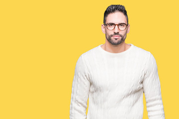 Young handsome man wearing glasses over isolated background Relaxed with serious expression on face. Simple and natural looking at the camera.